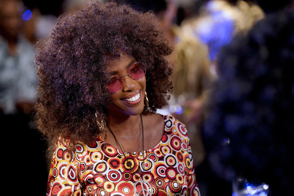 Dr Simone en robe fleurie et afro