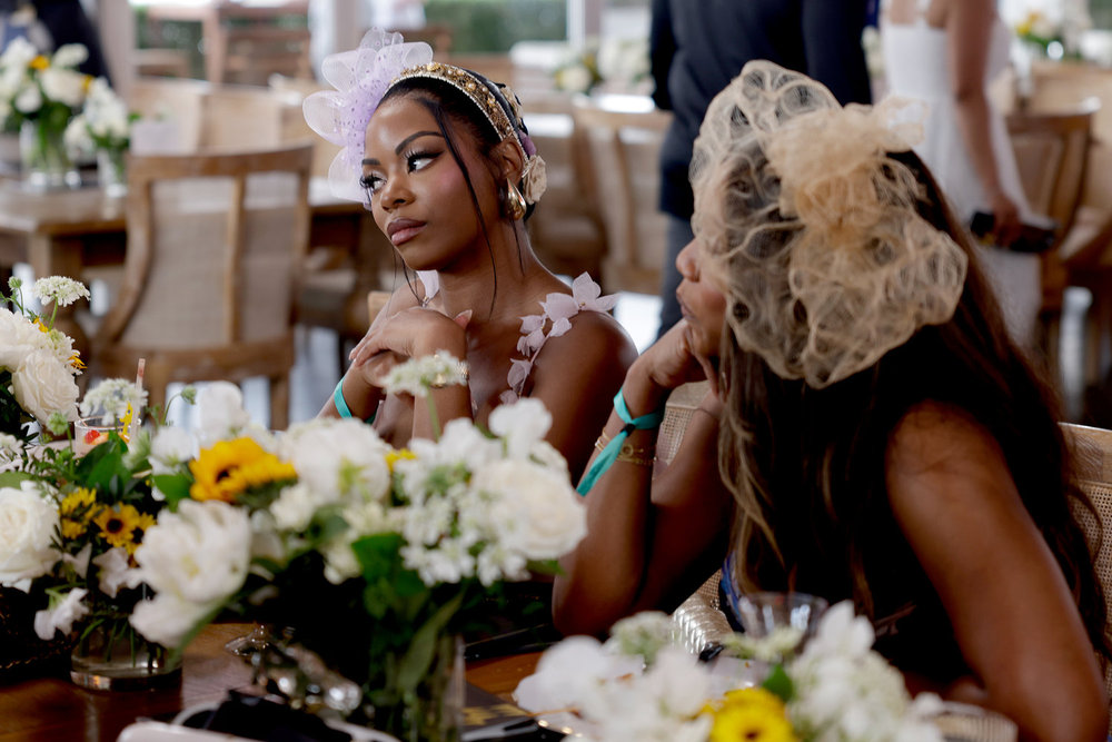 Keiarna Stewart et Tia Glover assises à une table avec des fleurs alors qu'elles assistaient à Preakness